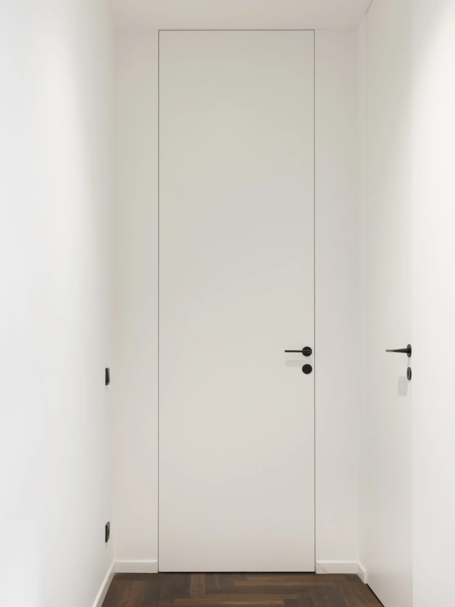Concealed aluminium frame built into the wall — the leaf flush with the plaster