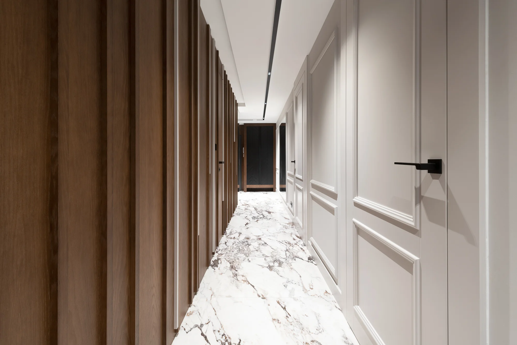 Integrated wall system with doors lacquered in white, a hallway with a marble floor — a Creadoor project
