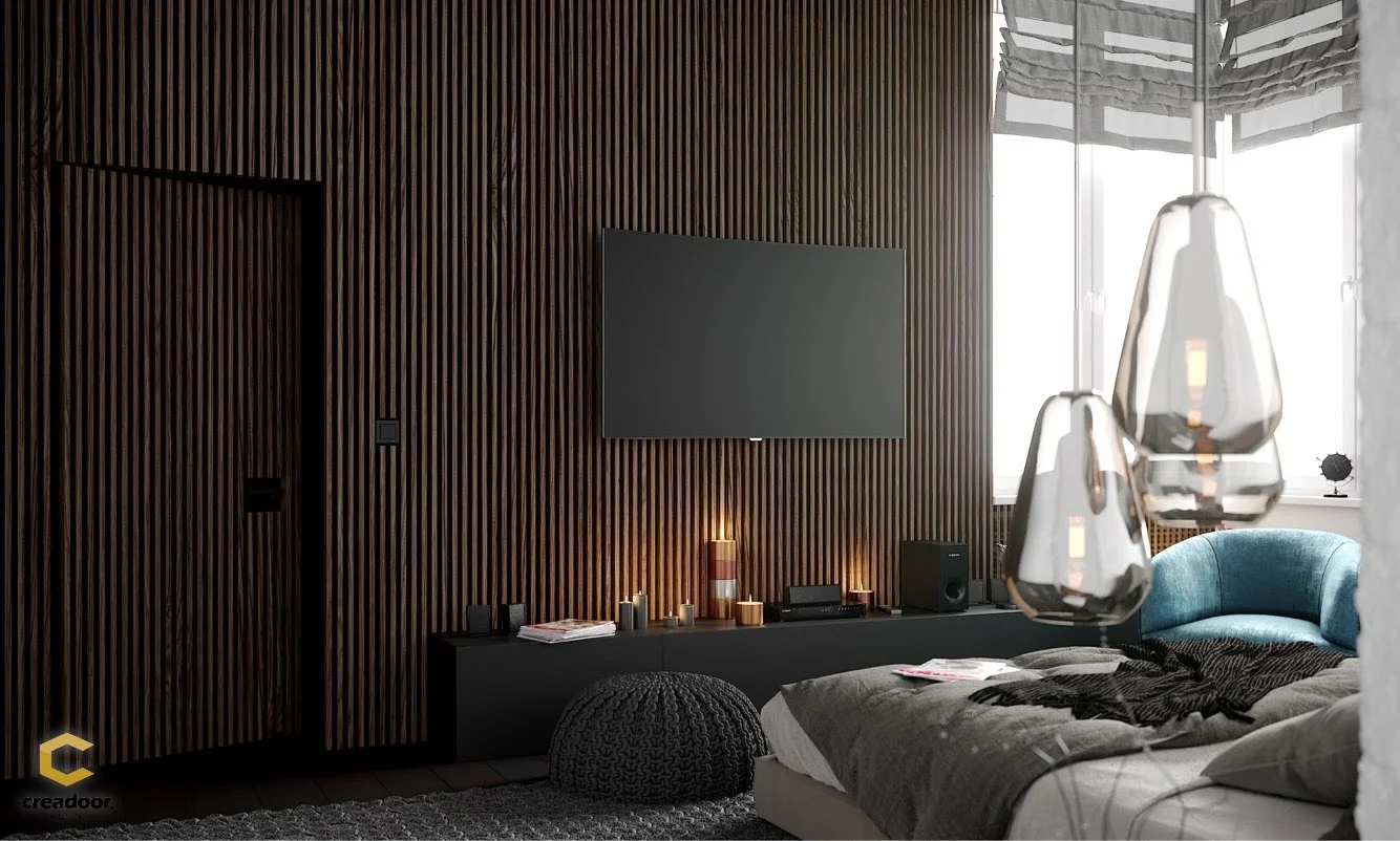 Integrated wall system in timber battens in a bedroom, concealed doors set into the wall beside the television — a Creadoor project
